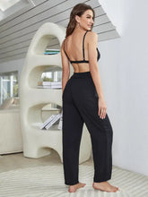 Black two-piece loungewear set with backless bralette and high-waisted wide-leg pants showing sleeve length detail from back