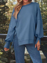 A soft dusty blue side slit oversized sweatshirt with ruffled sleeves made from comfortable fabric care instructions tumble dry low