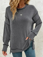 Gray ribbed knit side slit round neck sweatshirt with subtle stripes, small silver emblem, slightly stretchy fabric, machine wash cold care instructions