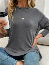 Side slit round neck sweatshirt in gray and black ribbed knit with slightly stretchy fabric and machine wash cold care instructions