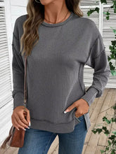 A cozy gray and white vertically striped side slit round neck sweatshirt with a relaxed fit and slightly stretchy fabric suitable for machine wash cold care instructions