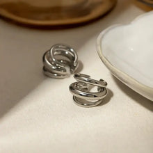 Silver spiral ring with layered cuff earrings in minimalist style