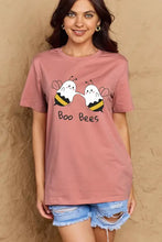 Woman in pink boo bees graphic cotton t-shirt and denim shorts