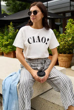Woman in Simply Love full size CIAO round neck short sleeve t-shirt and striped paperbag pants