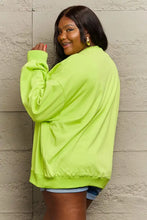 Woman in neon green drop shoulder full size sweatshirt with long sleeves