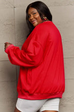 Woman in full size graphic sweatshirt with long sleeve length and white shorts