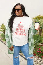 Plus-size woman in Simply Love Merry Little Christmas t-shirt, checkered cardigan, jeans, holding coffee