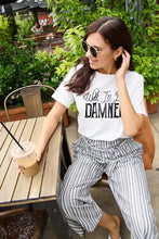 Woman in Simply Love size letter graphic short sleeve t-shirt and striped pants holding iced coffee