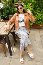 Woman in Simply Love size letter graphic short sleeve tee and moto outfit