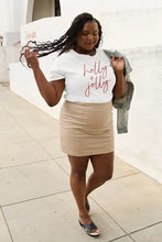 Woman in Simply Love letter graphic short sleeve t-shirt and beige mini skirt