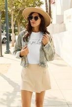 Woman in light wash denim jacket over Simply Love letter graphic short sleeve t-shirt