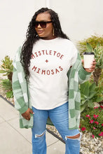 Woman in Simply Love Mistletoe Mimosas short sleeve tee with jeans