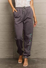 Dark gray Simply Love full size skeleton graphic sweatpants with colorful skeletal design on left leg