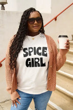 Woman in white Spice Girl short sleeve t-shirt and orange cardigan