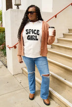 Woman in Spice Girl short sleeve t-shirt, orange cardigan, ripped jeans, brown platform loafers, holding coffee cup
