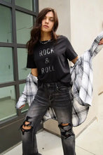 Young woman in Simply Love Rock and Roll short sleeve t-shirt and plaid shirt