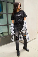 Woman in Simply Love Rock & Roll short sleeve t-shirt, ripped jeans, plaid shirt