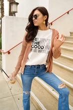 Peach knit cardigan with ribbed cuffs over Simply Love world short sleeve t-shirt