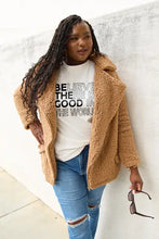 Woman in tan teddy bear coat and ripped blue jeans with Simply Love World Short Sleeve T-Shirt