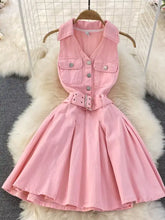 Pink sleeveless belted denim dress with button-front pockets and matching belt in denim fabric