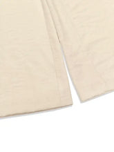 Sleeveless button front wide leg jumpsuit with beige linen trousers