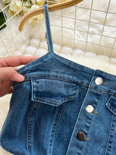 Blue denim sleeveless frayed hem mini skirt with front button closure and single shoulder strap denim dress detail