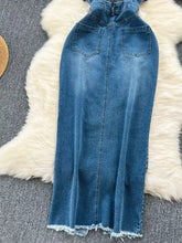 Back view of a sleeveless frayed hem denim dress in medium wash with a maxi length and zipper closure