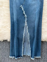 A mid-blue sleeveless frayed hem denim dress with a distressed front slit and matching raw hem detail