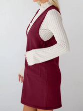 Sleeveless maroon knit pinafore dress with high neckline and front pockets
