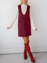 Sleeveless maroon knit dress with V-neck, pockets over cream ribbed top