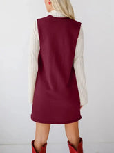 Sleeveless maroon knit dress with pockets over striped long-sleeve shirt