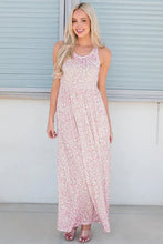 Blonde woman in sleeveless maxi dress pink and white floral pattern
