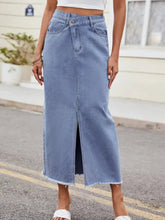 Light blue denim skirt with slit asymmetrical waist midi length and frayed hem made from denim material