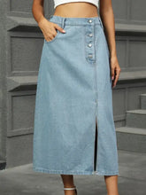 Light-wash denim midi skirt with front button closure and central slit in a stylish denim midi skirt design