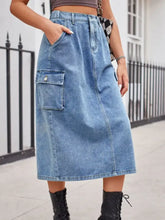 Medium-wash blue slit buttoned denim skirt with large front pocket and side seam detailing in buttoned denim skirt style