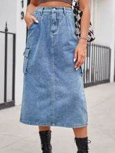 A mid-thigh length faded blue slit buttoned denim skirt with cargo pockets and a classic button closure