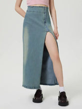 A light blue wash high-waisted denim skirt with front slit raw hem and zip closure slit denim skirt