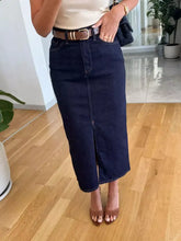 Dark blue denim skirt with front slit and classic stitching showcasing key denim skirt features, tumble dry safe
