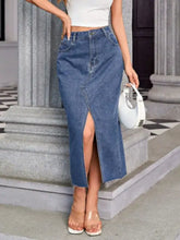 Mid-thigh length blue denim skirt with front slit, frayed hem, and pockets in a midi denim skirt style
