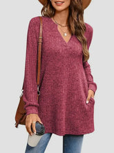 Woman in slit notched pocketed long sleeve deep berry V-neck tunic