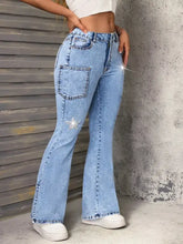 Light-wash denim slit star flare leg jeans with sparkling star embellishment on the thigh