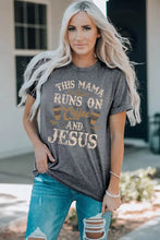 Woman in slogan graphic round neck short-sleeve tee and distressed blue jeans