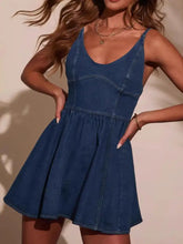 A fitted medium-wash blue denim mini dress with a flared skirt and smocked back adjustable straps
