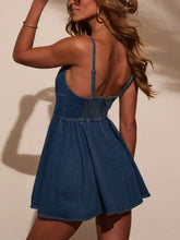 Blue denim mini dress with thin straps and smocked back detail showing the back side of this denim mini dress