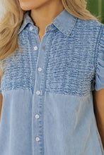 Light blue denim dress with smocked collared neck and ruched detailing on the chest and cap sleeves