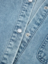 Light blue denim shirt mini dress with silver-toned buttons, visible stitching, and smocked cuffs