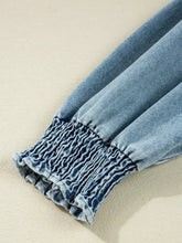 Light-wash denim dress sleeve with smocked cuffs and gathered ruched detail on a denim shirt mini dress
