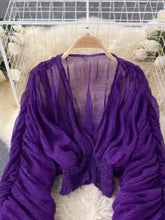 A sheer deep purple smocked ruched long sleeve blouse with crocheted hemline and ruched sleeves