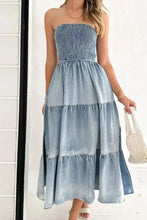 Strapless denim dress with a smocked tube slit bodice and tiered flowing skirt in blue denim fabric