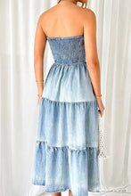 Denim dress featuring a smocked tube slit bodice with tiered ruffles in a strapless maxi style